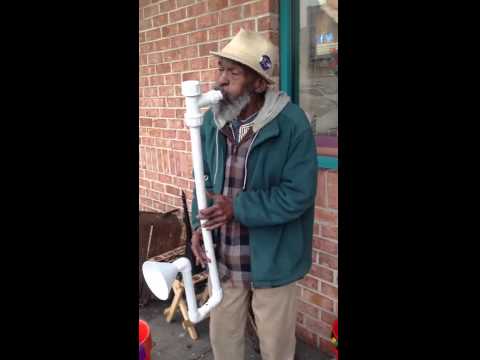 عجوز يعزف على آلة مصنوعة من الأدوات الصحية